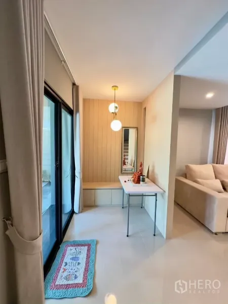 Detached House for rent in Samut Prakan - Hallway with sliding glass doors, built-in bench and soft pendant lighting.