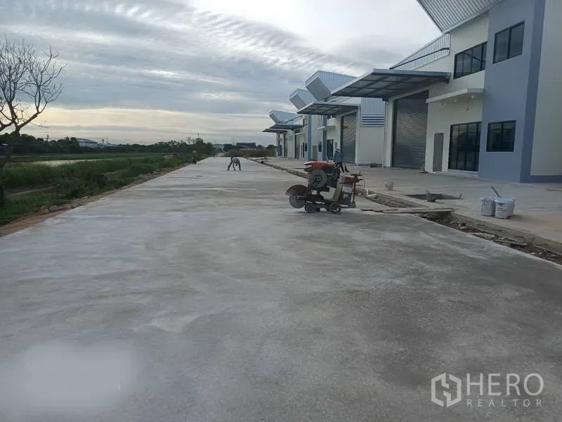 工厂 出租在Bang Phli, Samut Prakan - 仓库排外侧的宽混凝土车道，可通行大型卡车并设有雨棚装卸位。