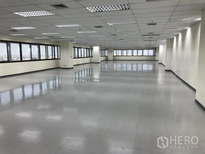 Office Space for rent in Bang Na, Bangkok - Bright large office area with tiled floors, drop ceiling, air-conditioning vents and wraparound windows offering city views.