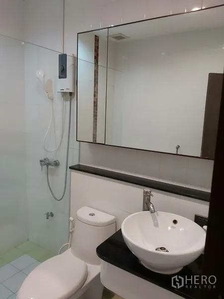 Townhouse for rent in Din Daeng, Bangkok - Clean bathroom with glass shower, water heater, wide mirror, vessel sink and toilet.