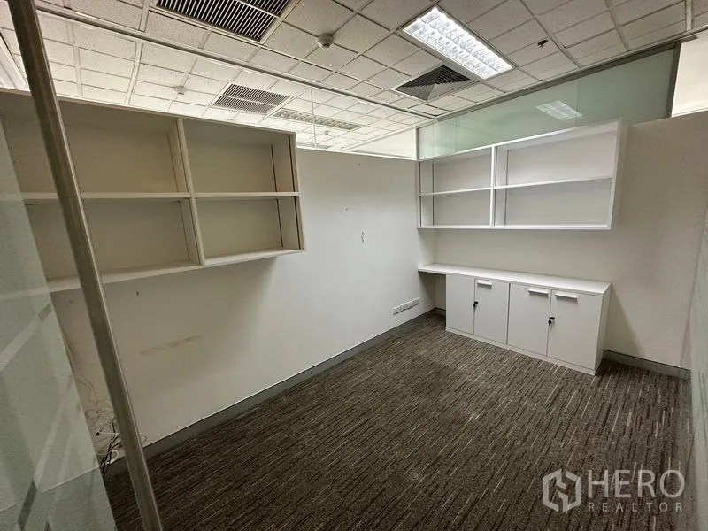 Office Space for rent - Workroom with built-in shelves and cabinets beneath a suspended acoustic ceiling.