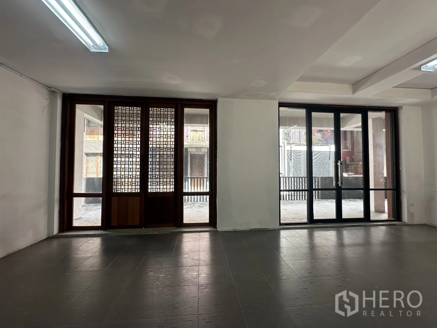 Home Office for rent in Pathum Wan, Bangkok - Bright workspace with twin sliding doors and lattice wood windows facing the inner courtyard.