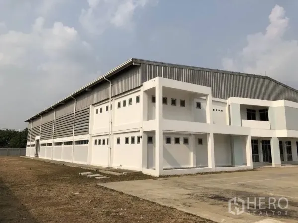 Factory for rent in Bang Pa-in, Phra Nakhon Si Ayutthaya - Side view of steel-clad warehouse facade with front parking and loading apron.