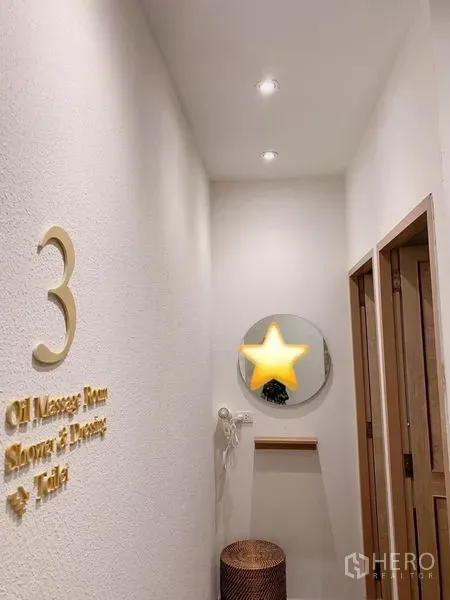Shophouse for rent in Khlong Toei, Bangkok - Bright corridor with numbered doorways, a round mirror and soft ceiling lights.