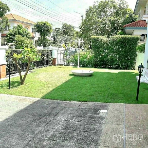 Detached House for rent in Prawet, Bangkok - Private lawn garden with paved patio, boundary hedge and outdoor lamp posts.