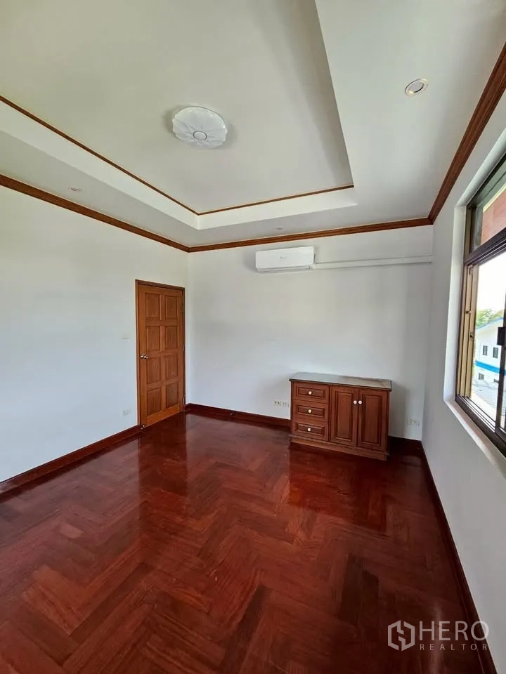Home Office for rent in Wang Thonglang, Bangkok - Bright room with herringbone hardwood floor, tray ceiling, air conditioner, wood door and window.