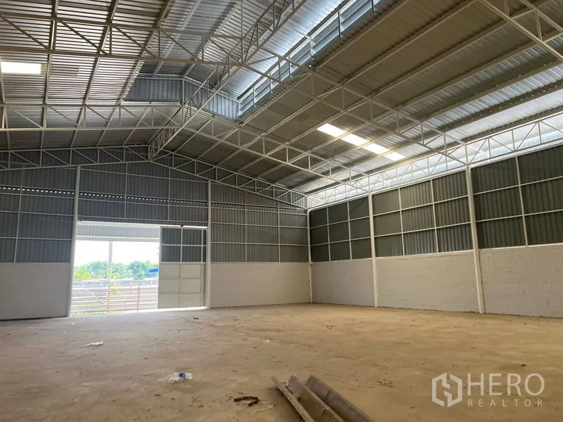 Warehouse for rent in Min Buri, Bangkok - Warehouse interior facing large sliding door allowing truck access and daylight.