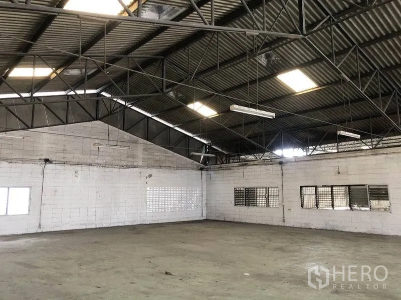 货栈 出租在Mueang Pathum Thani, Pathum Thani - 宽敞的仓库内部，高钢结构屋顶，天窗采光，通风砖墙与耐用混凝土地面。