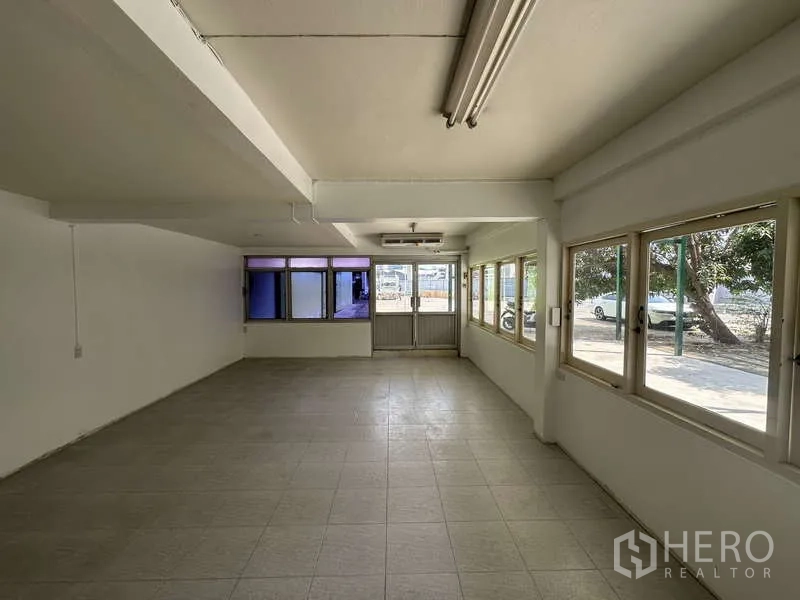 Warehouse for rent in Pak Kret, Nonthaburi - Open office space with fluorescent lighting, wraparound windows and door to the yard.