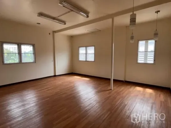 Warehouse for rent in Bang Phli, Samut Prakan - Large upper-floor room with wood-look flooring, multiple windows and pendant lights.