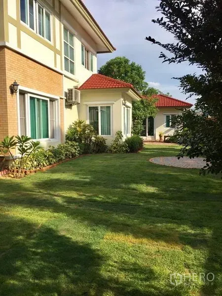 บ้าน ขายในPak Kret, Nonthaburi - มุมข้างบ้าน หลังคากระเบื้องสีแดง พร้อมสนามหญ้าและจัดสวนกว้าง