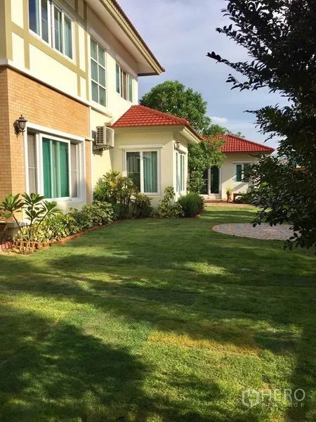 บ้าน ขายในPak Kret, Nonthaburi - มุมข้างบ้าน หลังคากระเบื้องสีแดง พร้อมสนามหญ้าและจัดสวนกว้าง