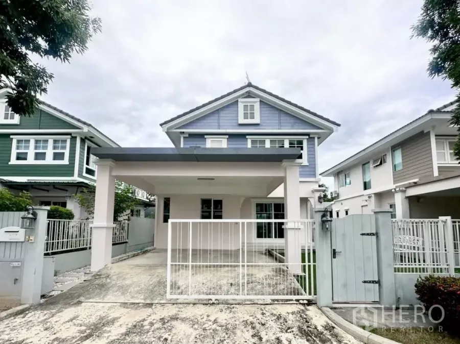 独立式住宅 出租在Bang Phli, Samut Prakan - 两层蓝色独栋别墅外观，带有顶车棚与前院铁门。