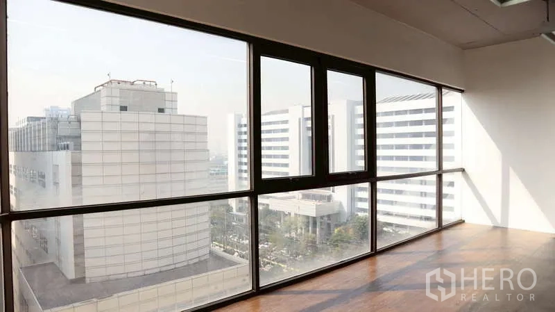 办公空间 出租 - 落地窗办公室俯瞰现代建筑与城市景观，木地板采光充足。