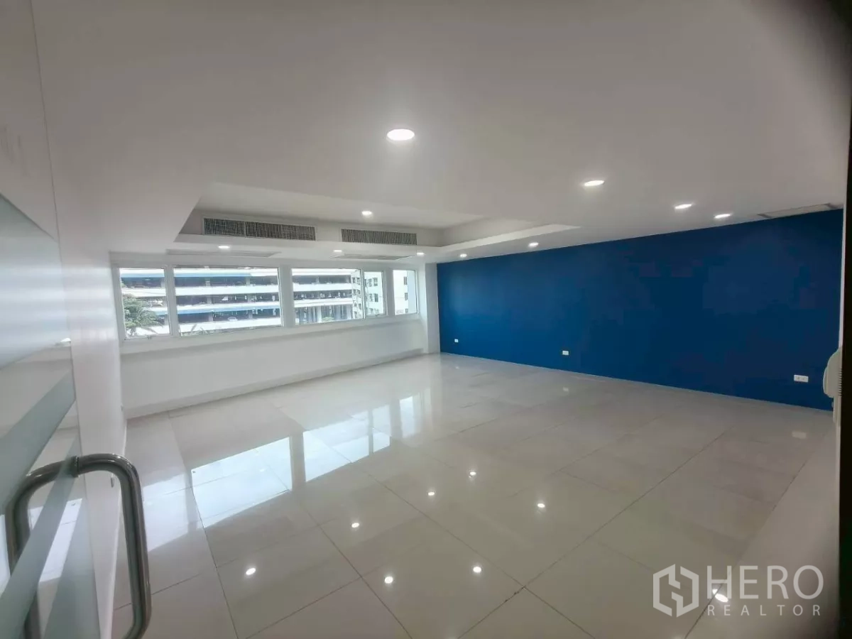 Office Space for rent in Chatuchak, Bangkok - Private office with blue accent wall, long windows, and recessed spotlights