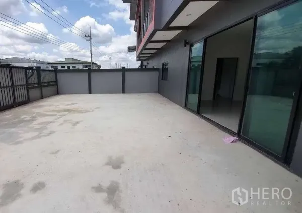 Warehouse for rent in Pathum Thani - Wide concrete yard for truck parking and loading beside the warehouse with glass-front office.