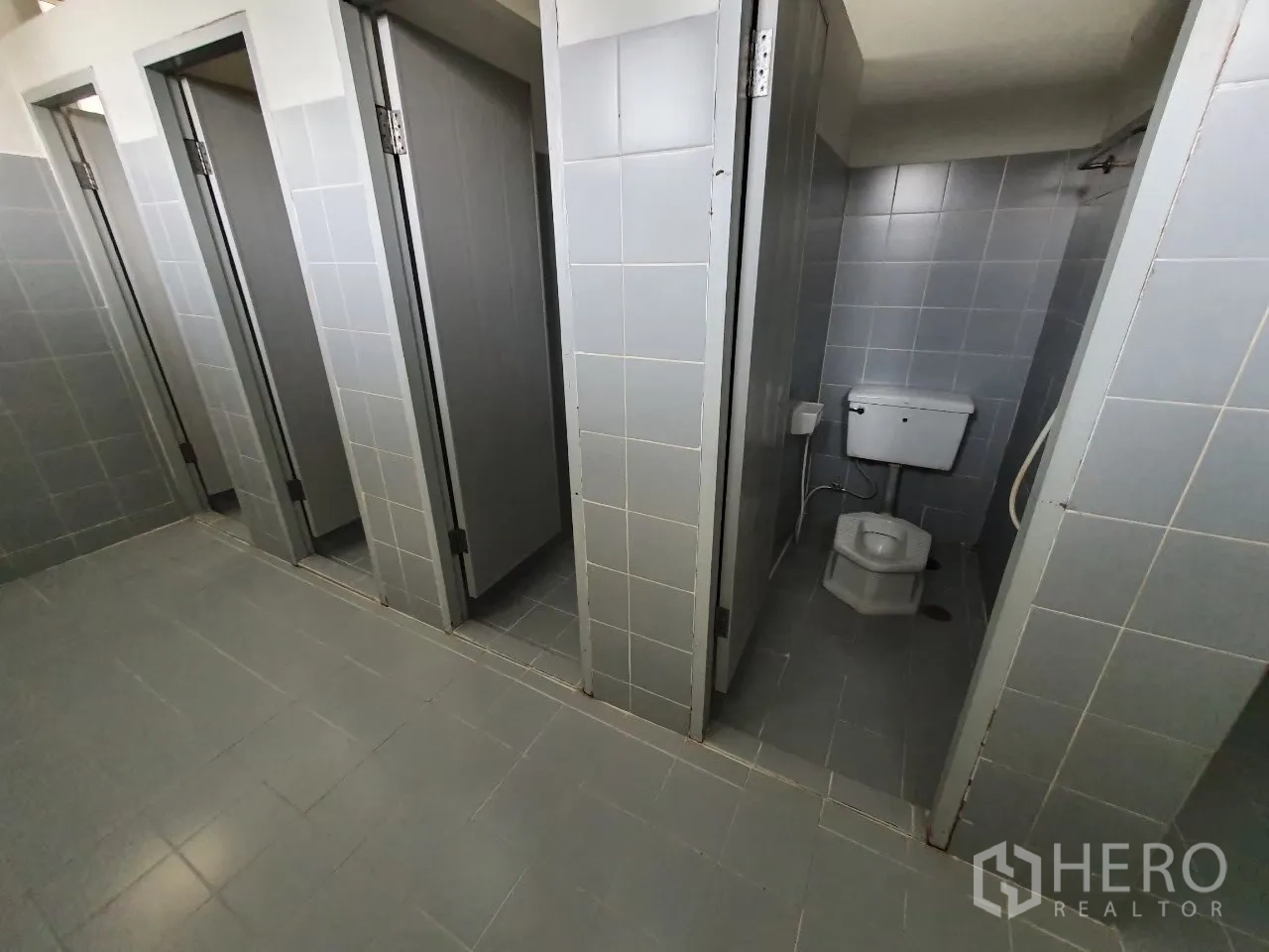 Factory for rent in Bang Pa-in, Phra Nakhon Si Ayutthaya - Tiled restroom area with several cubicles and squat toilets.