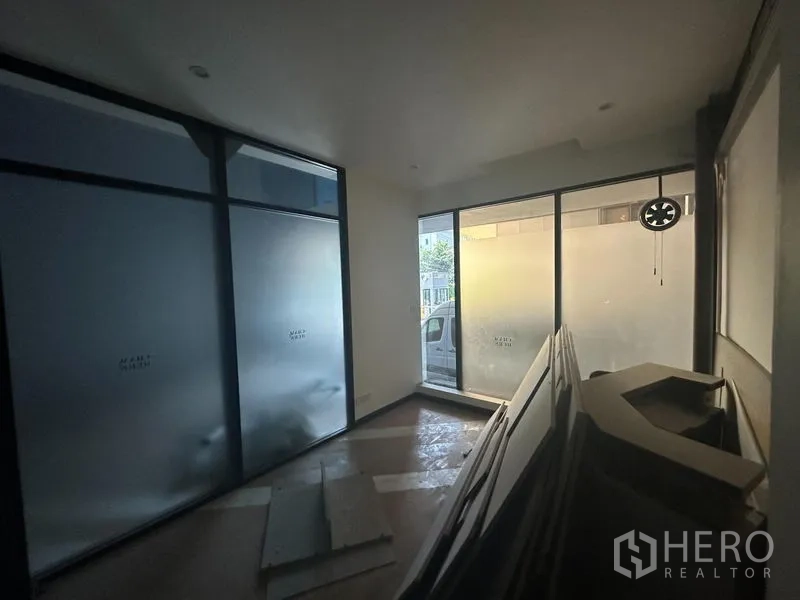 办公空间 出租在Khlong Toei, Bangkok - 前厅小房，落地磨砂窗与堆放的装修材料。