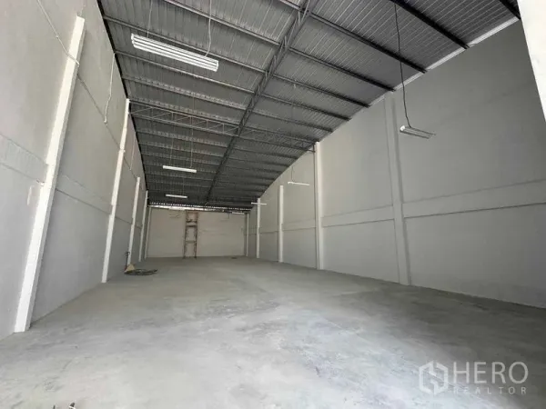 Warehouse for rent in Mueang Samut Sakhon, Samut Sakhon - Long, column-free warehouse interior with high steel roof, LED lighting, and smooth concrete floor.