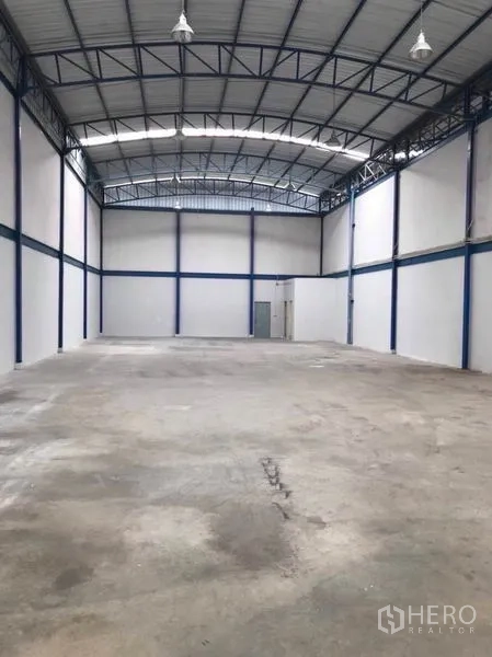 工厂 出租或出售在Mueang Samut Sakhon, Samut Sakhon - 高挑仓库大厅，钢结构屋顶、混凝土地面与服务门。