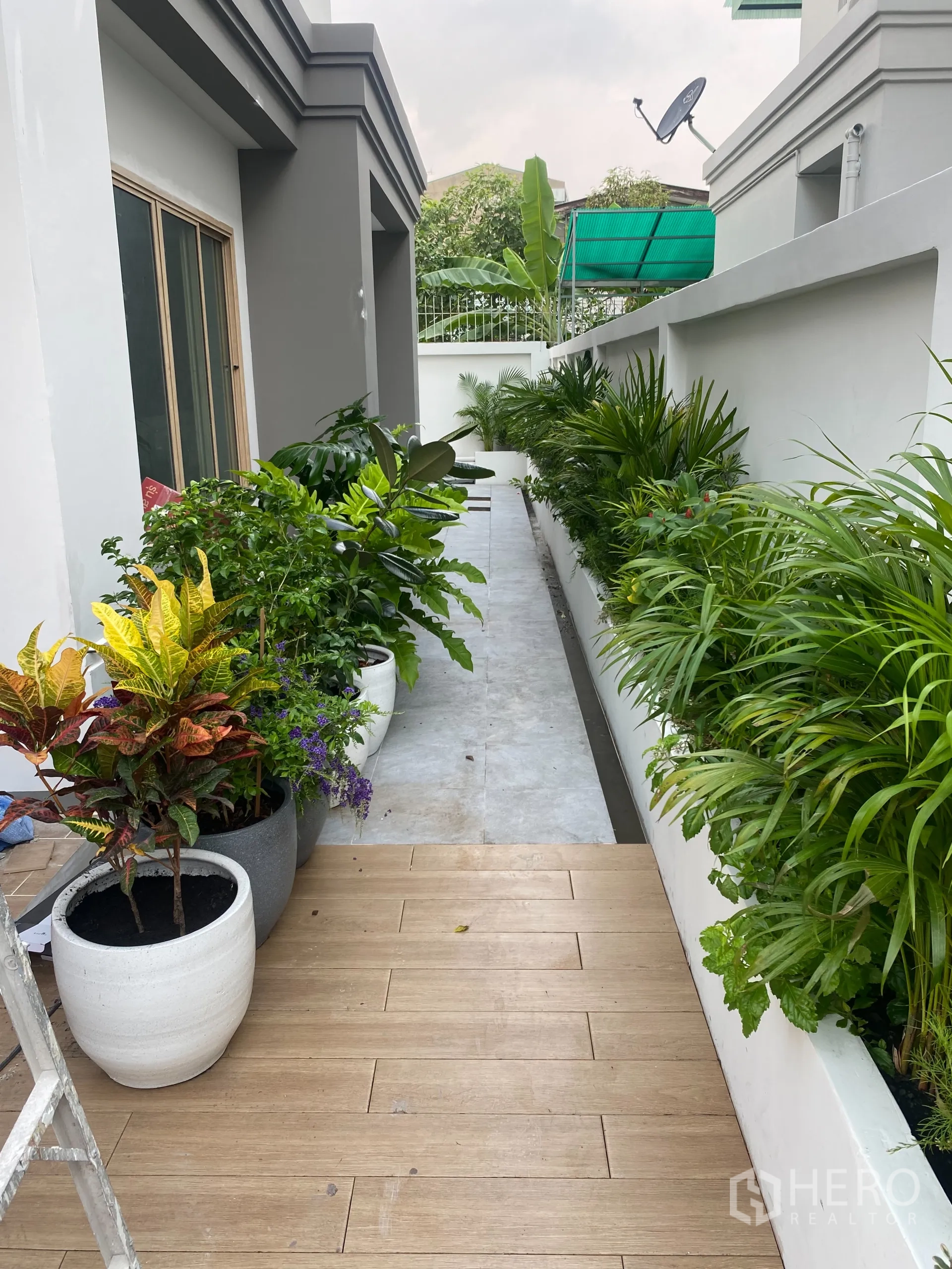 Detached House for sale in Suan Luang, Bangkok - Landscape bed and potted plants along the side terrace beside sliding doors.