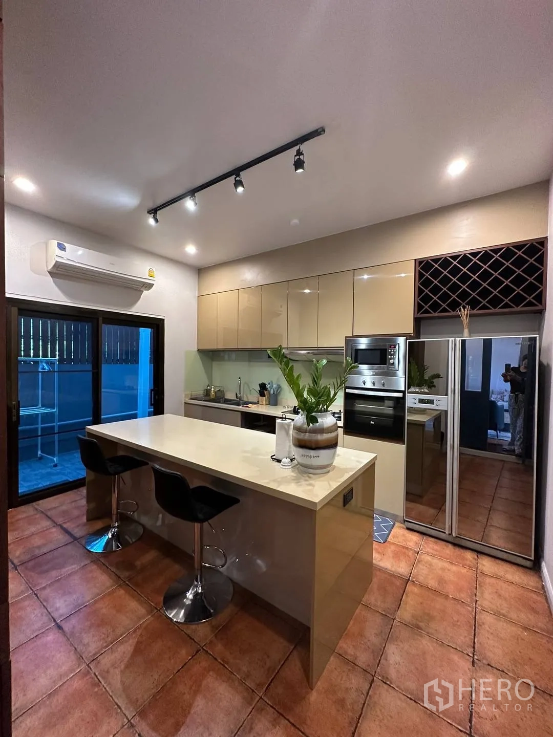 Detached House for rent in Watthana, Bangkok - Contemporary kitchen with island breakfast bar, built-in oven and track lighting.