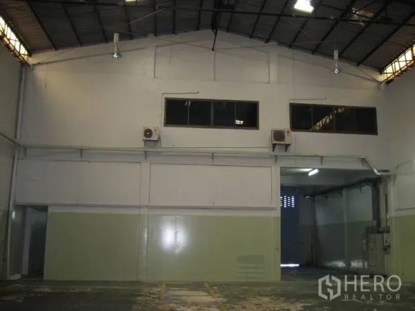工厂 出租在Bang Sao Thong, Samut Prakan - 装卸区入口，卷帘门，上方夹层窗与空调机组。