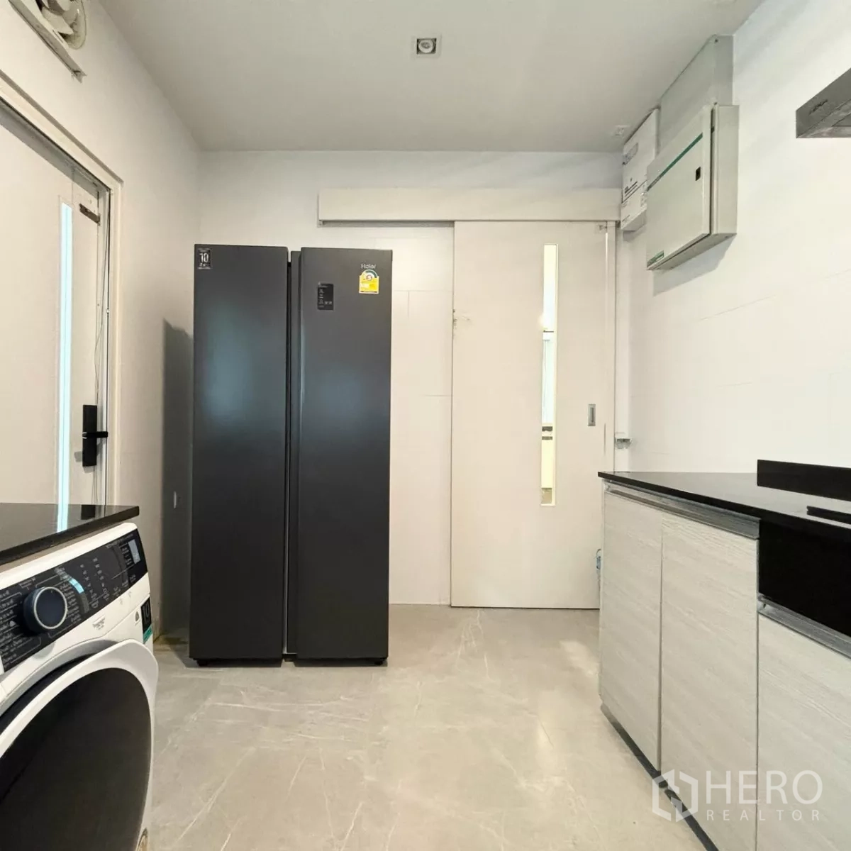 Detached House for rent or sale in Prawet, Bangkok - Utility room with double-door refrigerator, sliding door and ample storage.