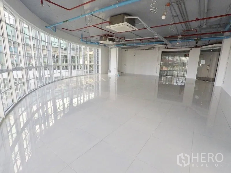 Retail Space for rent in Khlong Toei, Bangkok - Daylit showroom-style interior featuring wraparound windows, tiled floors, and ducted air-conditioning.