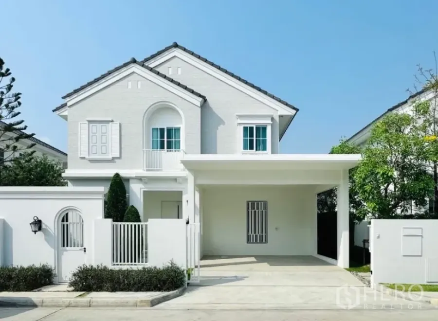 Detached House for rent in Bang Phli, Samut Prakan - Front view of a modern white two-storey detached house with carport and gate.