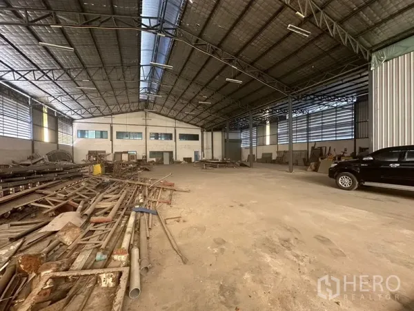 Warehouse for rent in Saphan Sung, Bangkok - High-ceiling warehouse hall with steel trusses, skylights and open storage area.