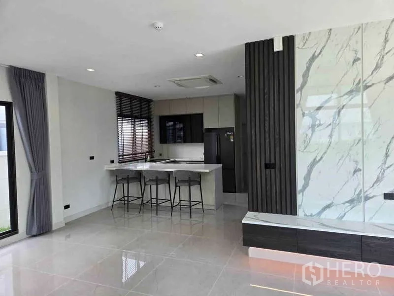 独立式住宅 出租在Bang Phli, Samut Prakan - 开放式客餐厅，大理石特色墙与中岛。