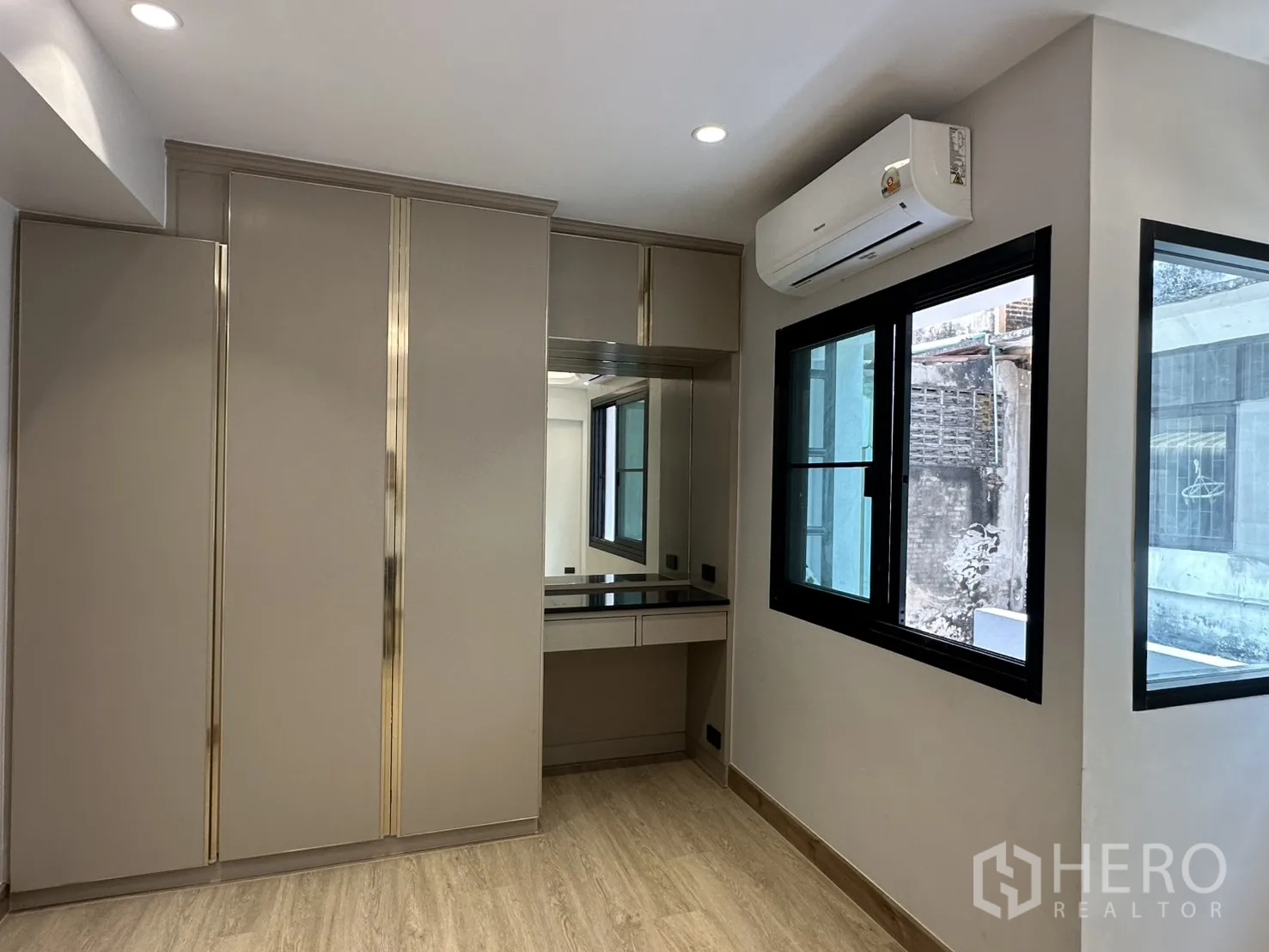 Home Office for rent in Watthana, Bangkok - Corner bedroom with wardrobe, vanity and air conditioner by windows.