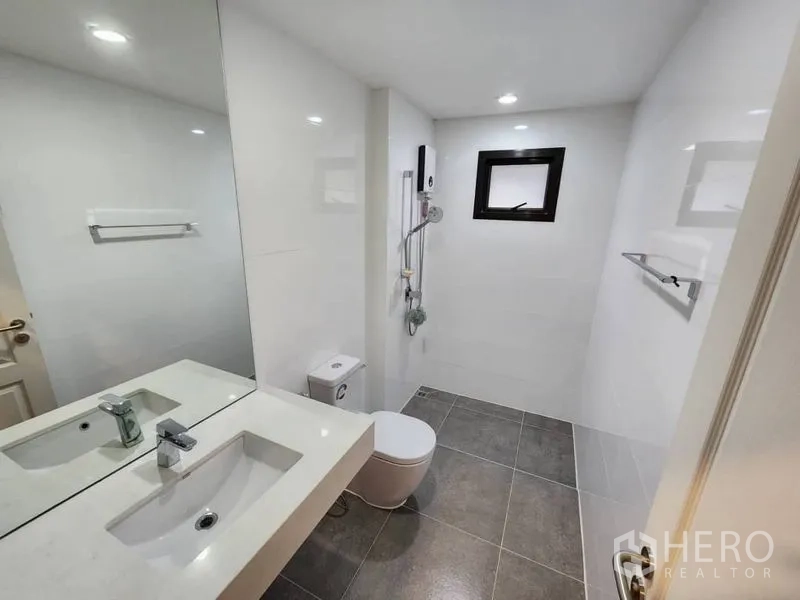 Detached House for rent in Prawet, Bangkok - Bright bathroom with large mirror, white walls, window and shower with water heater.