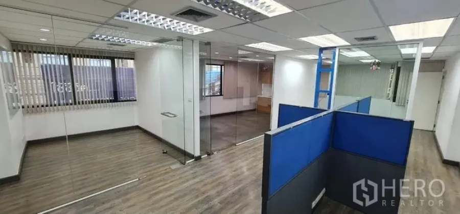 办公空间 出租在Watthana, Bangkok - 采光充足的开放式办公室，玻璃隔断、蓝色工位与木纹地板。