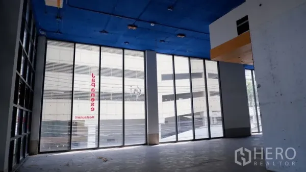Retail Space for rent in Watthana, Bangkok - Corner retail frontage with tall glass panels and high ceiling facing the street.