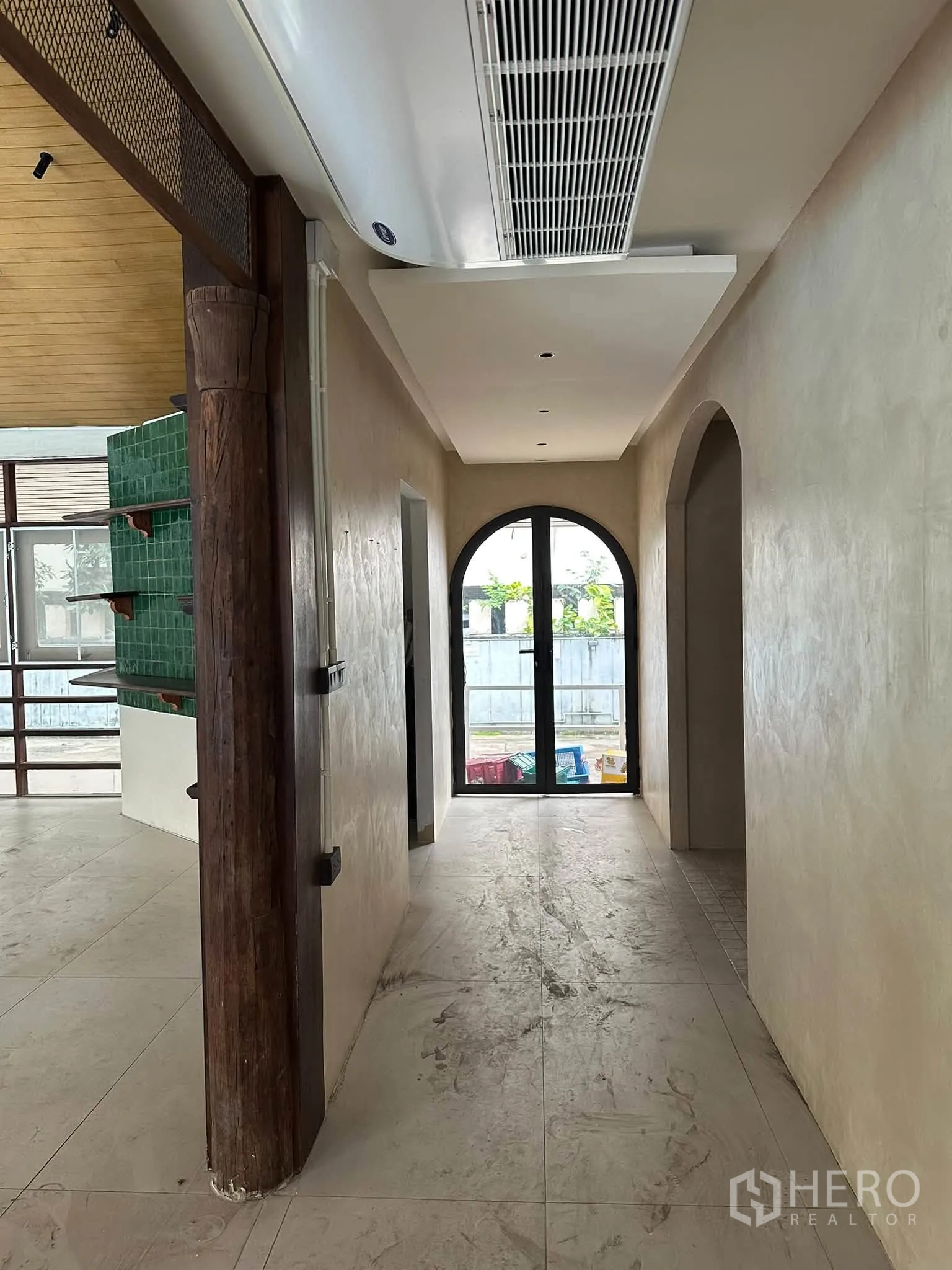 Retail Space for rent in Khlong Toei, Bangkok - Corridor with ceiling-mounted air unit and arched door to a glass exit.