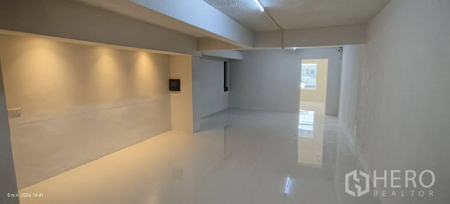Shophouse for rent in Watthana, Bangkok - Long corridor workspace with tiled floor, exposed conduits, and electrical panels.