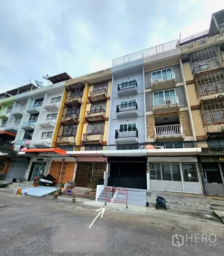 Shophouse for rent - Front facade of renovated multi-storey shophouse with roller shutter and balconies in Bang Na.