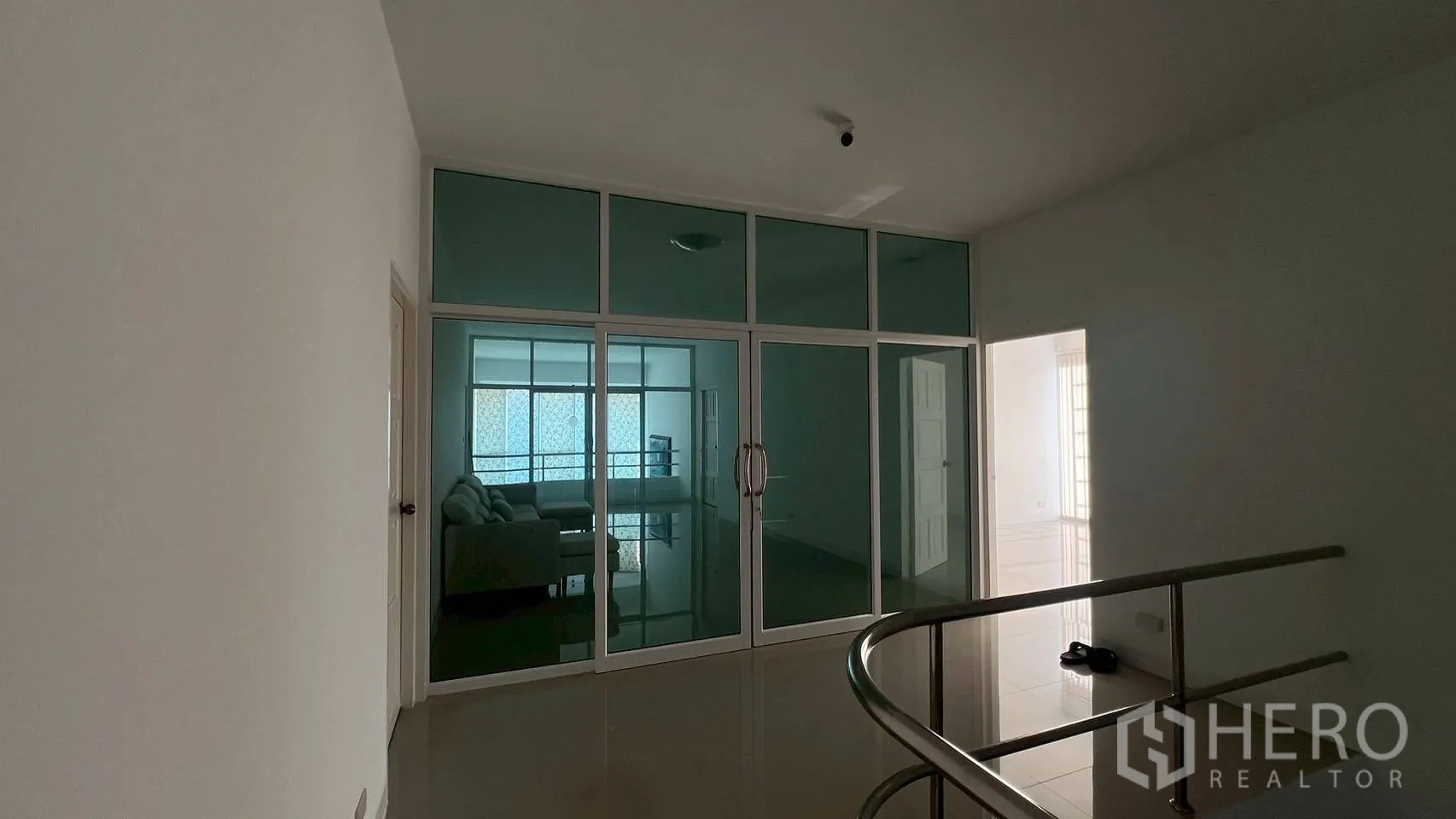Home Office for rent in Wang Thonglang, Bangkok - Upper landing with stainless handrail facing a glass-partitioned room.