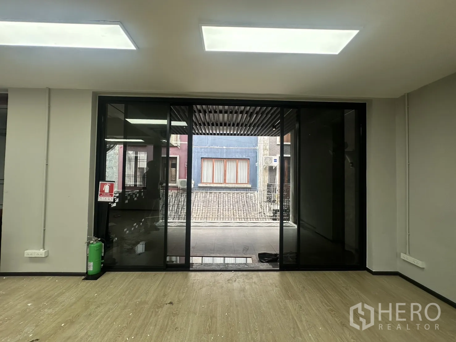 Home Office for rent in Pathum Wan, Bangkok - Office room with sliding glass wall opening to the balcony and bright LED panels.