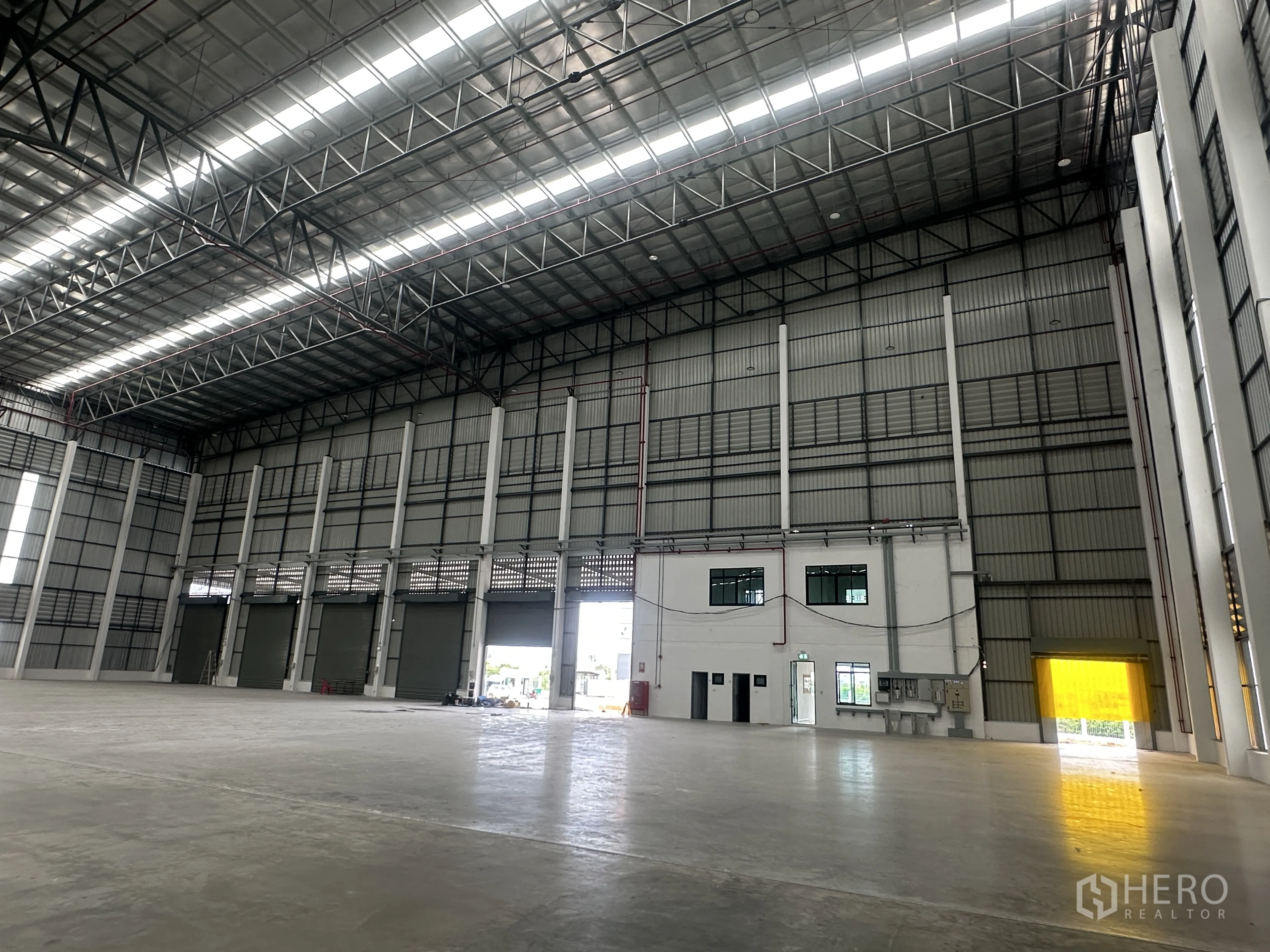 工厂 for rent in Bang Phli, Samut Prakan - 室内装卸区设多扇卷帘门，旁接两层办公楼。