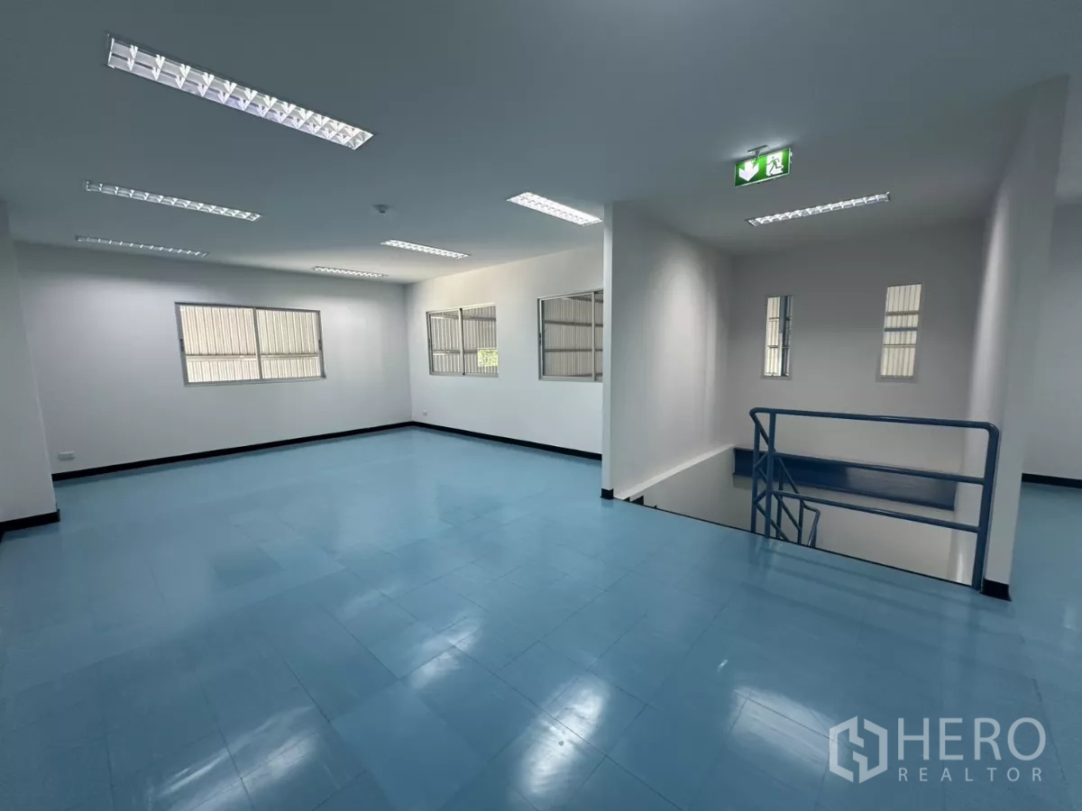 Factory for rent in Bang Phli, Samut Prakan - Upper-level office zone with exit sign, stair rail and blue floors.