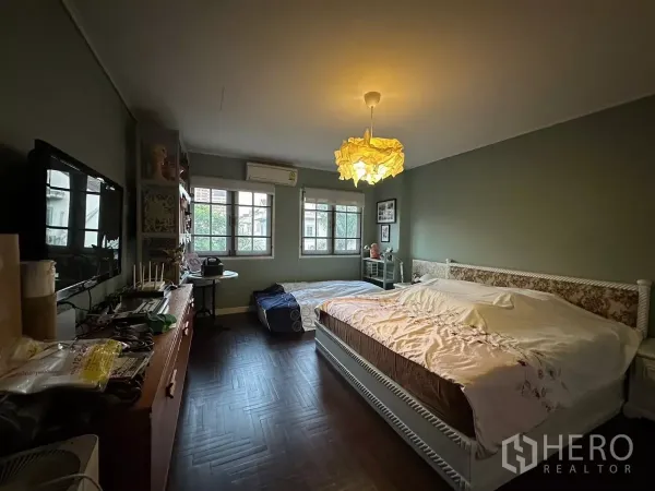 Townhouse for rent in Watthana, Bangkok - Cozy bedroom with windows, pendant light, air conditioner and a large bed.
