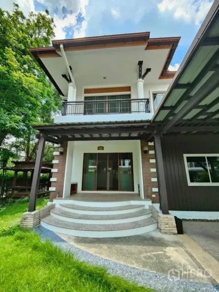 Detached House for rent or sale in Mueang Nonthaburi, Nonthaburi - Grand front entrance with curved steps, balcony above and landscaped lawn.