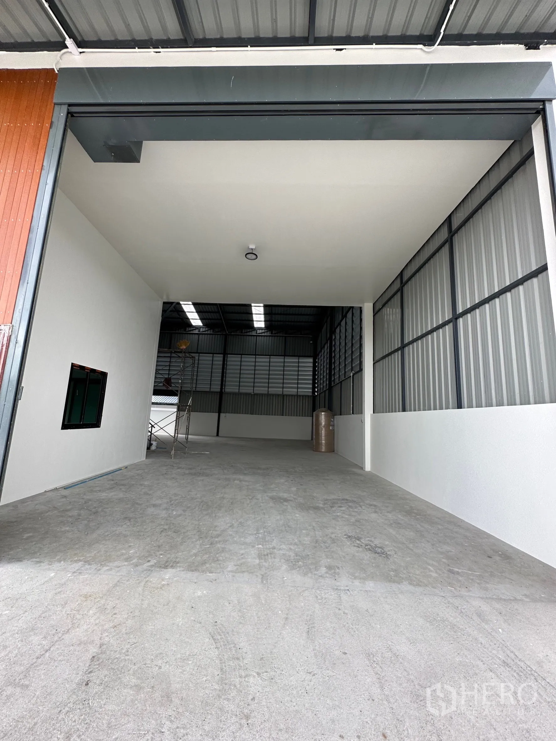 Warehouse for rent or sale - Wide entrance into a high‑bay warehouse with concrete floor and metal roof.