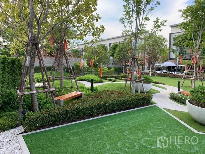 Townhouse for rent or sale in Prawet, Bangkok - Landscaped communal garden with benches, walking paths and an activity lawn.