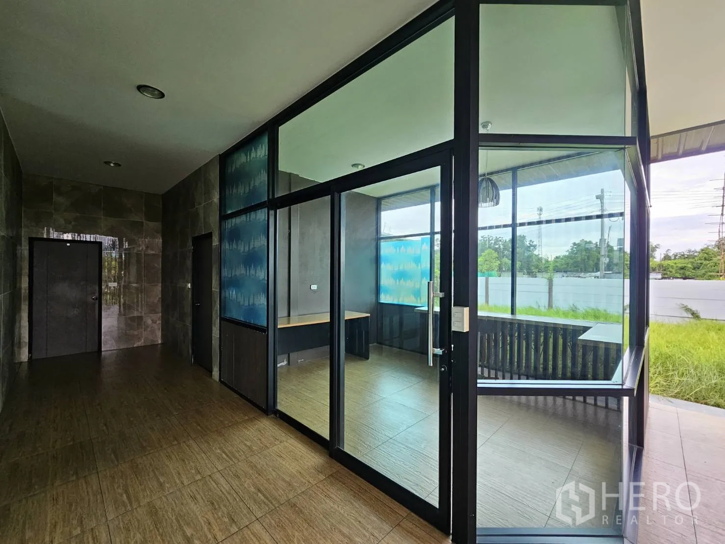 Warehouse for rent in Lam Luk Ka, Pathum Thani - Glass-walled office entrance and lobby area facing the garden.