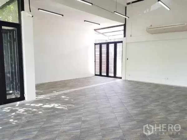 Office Space for rent in Chatuchak, Bangkok - Corner workspace featuring folding glass doors, high ceiling, and tiled flooring.