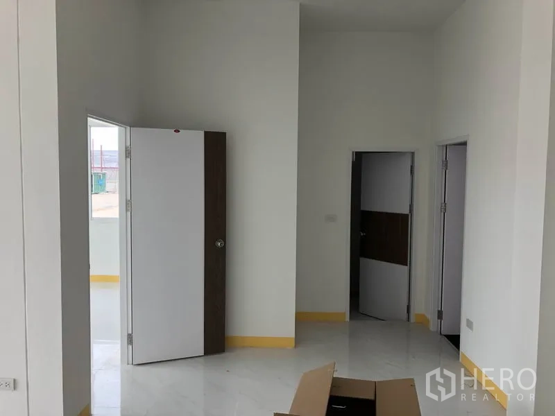 Factory for rent or sale in Sai Noi, Nonthaburi - Bright office corridor with white walls, multiple doors and glossy tile flooring.